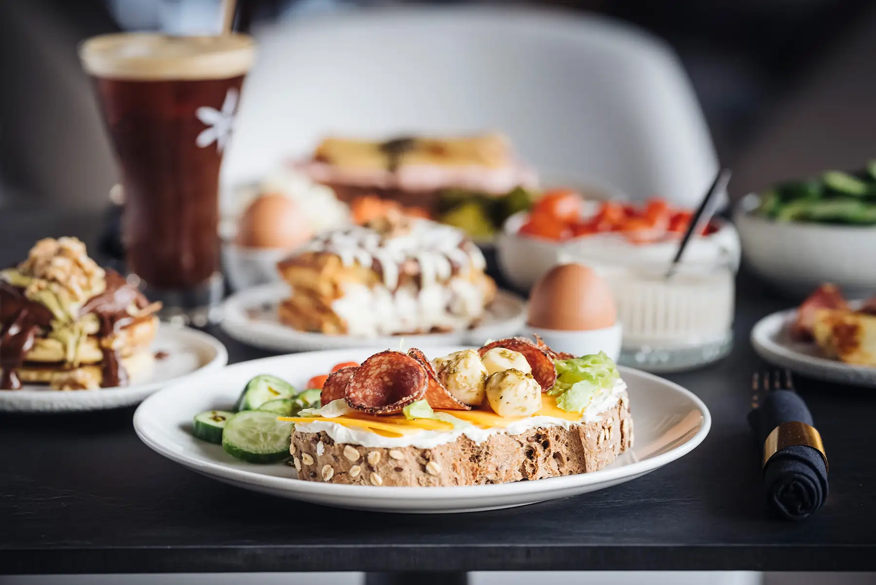 DIY breakfast toast topped with cheese, salami, and veggies at Bread and Spread