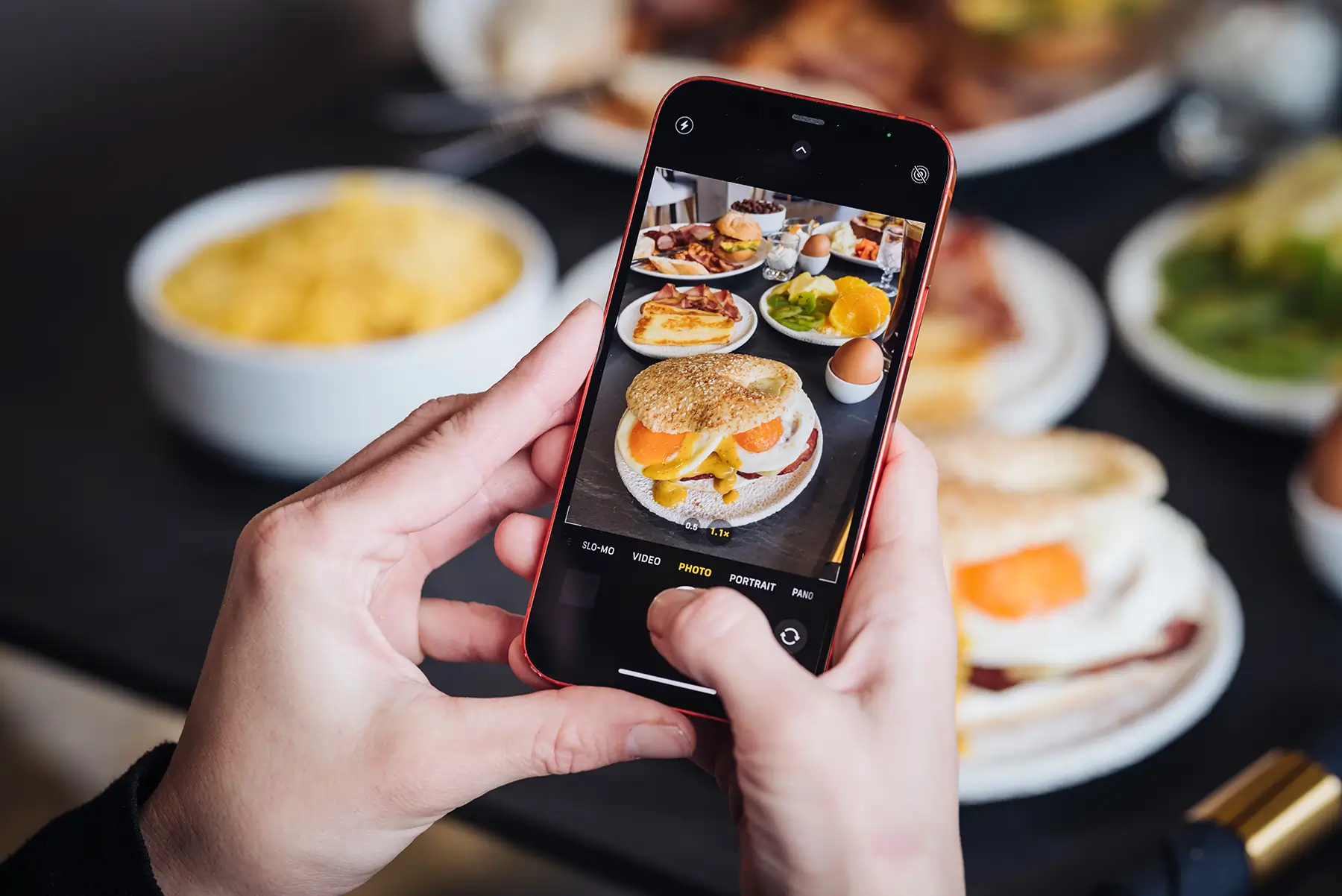 Smartphone capturing photo of colorful breakfast plate at Bread and Spread