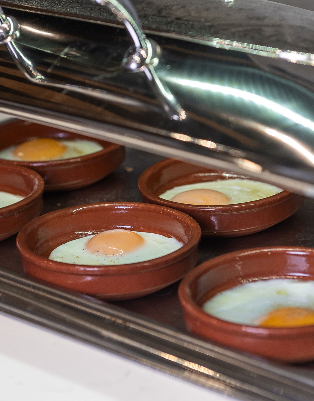 Baked sunny side up eggs in clay pots at Bread & Spread